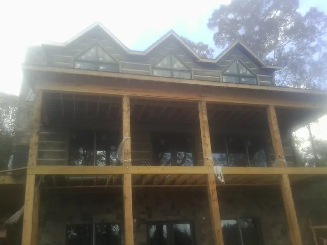 Dormers and porch framing on a large log home under construction — Roof Coating work by our crew in Washington